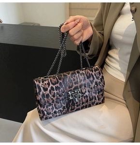 Détail du sac à motif léopard avec clous argentés et bandoulière en chaîne métallique