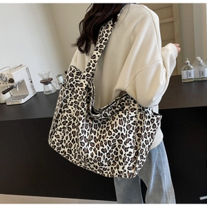 Dettaglio laterale della borsa tote in tela leopardata con ampia tasca portaoggetti