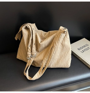 Detail der khakifarbenen Plissee-Schultertasche mit verstellbarem Gurt und Schnalle