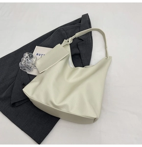 Détail du sac cabas en cuir crème avec texture grainée et bandoulière nouée