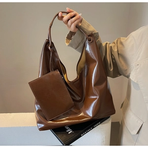 Detail view of a large brown PU leather hobo bag with a matching small square pouch