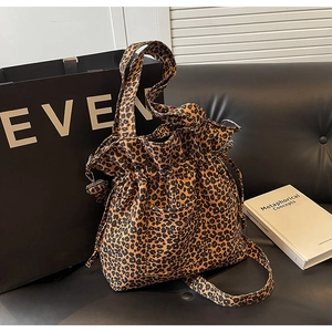 Close-up of leopard print canvas shoulder bag with drawstring closure and side pocket