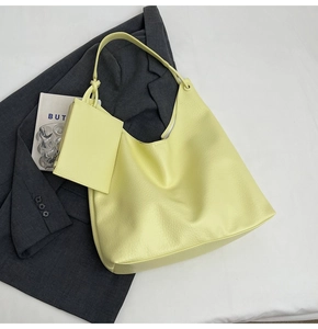 Détail du grand sac hobo en cuir litchi jaune avec une petite pochette zippée assortie