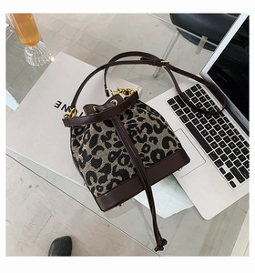 Detail of leopard print jacquard bucket bag with brown leather base and gold hardware