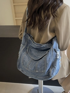 Fashionable large denim tote bag with multiple pockets and vintage washed distressed finish