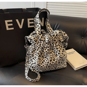 Detail of the leopard print canvas tote bag with drawstring closure and shoulder strap