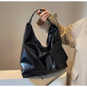 Detail of high-gloss black hobo tote bag with a matching detachable mini pouch