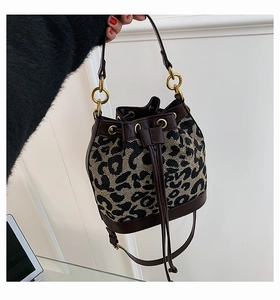 Detail of leopard print bucket bag with drawstring closure and dark brown leather trim