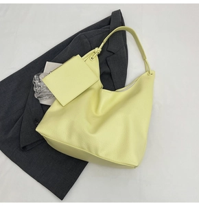 Détail d'un grand sac hobo jaune citron avec texture litchi et une petite pochette zippée assortie