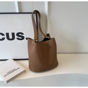 Détail du sac seau en cuir grainé marron avec boucle dorée et bandoulière élégante de qualité