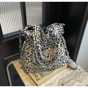 Detail view of large leopard print canvas tote bag with drawstring and wide straps