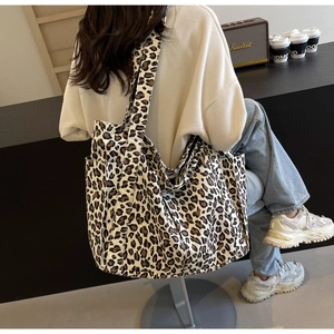 Dettaglio della borsa tote in tela leopardata con tasche laterali e tracolla coordinata