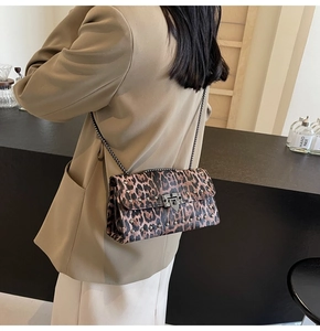 Détail du sac baguette léopard avec rivets argentés et bandoulière chaîne en métal