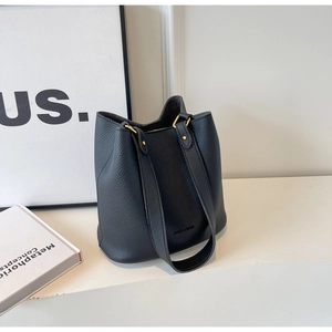 Détails du cuir noir grainé litchi et des ferrures dorées sur le grand sac seau