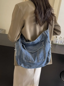 Retro wash blue denim tote bag with large front pocket and frayed edges for women