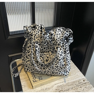 Detail of leopard print canvas tote bag featuring adjustable strap and front pocket