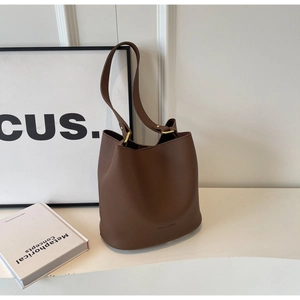 Détail d'un sac seau en cuir marron avec motif litchi et boucles dorées élégantes