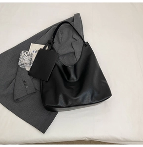 Détail du grand sac hobo noir avec texture cuir et mini pochette zippée attachée au sac