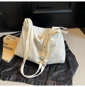 Detailansicht der weißen Plissee-Tasche mit verstellbaren breiten Trägern und Metallteilen