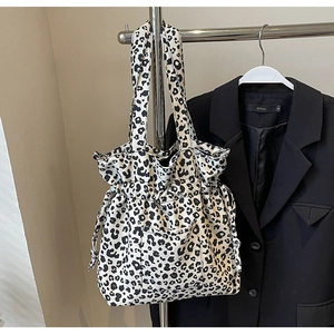 Close-up of leopard print canvas tote bag with drawstring closure and front pocket