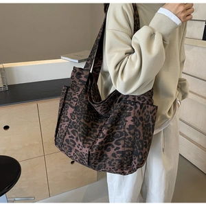 Vista dettagliata della grande borsa tote leopardata con tracolla larga e tasca laterale