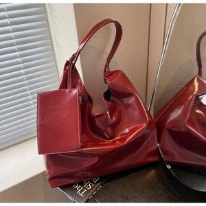 Close-up of high-gloss burgundy leather tote with matching small coin purse detail