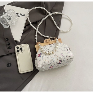 Close-up of white crossbody bag with butterfly embroidery, sequins and pearl beads