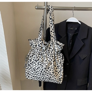 Detail of leopard print canvas tote bag featuring drawstring closure and front pocket