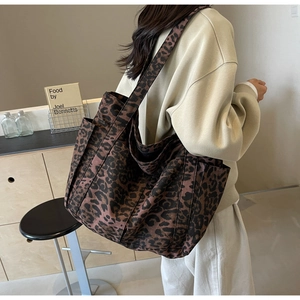 Detailed side view of large leopard print tote bag with practical side pocket on model