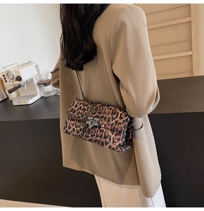 Modèle portant un sac léopard avec chaîne, rivets métalliques et fermoir noir