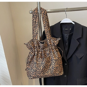 Detail of leopard print canvas tote bag with drawstring closure and outer pocket