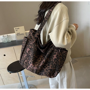 Detailed side view of large leopard print tote bag with side pocket on a female model