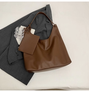 Détail macro du cabas en cuir marron foncé avec une petite pochette zippée assortie
