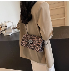Détail du sac baguette léopard avec clous argentés et bandoulière en chaîne chic
