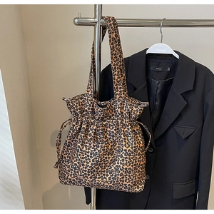 Leopard print canvas drawstring tote bag detail showing pocket and shoulder strap on hanger
