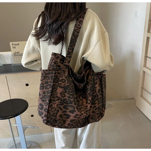 Detail of large leopard print tote bag with thick canvas texture and sturdy shoulder straps