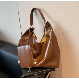 Detail of a large brown PU leather hobo bag with a matching detachable zipper pouch