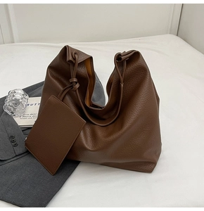 Détail de la texture en cuir grainé marron foncé sur un grand sac cabas fourre-tout