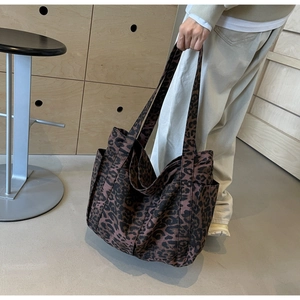 Detail view of large leopard print tote bag with side pocket and reinforced shoulder straps