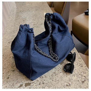 Detailed view of large denim hobo bag with metal chain strap and pleated soft texture