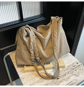 Detailansicht der khakifarbenen Plissee-Tasche mit verstellbarem Riemen und Metallschnalle