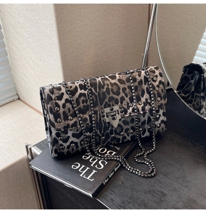 Détail du sac bandoulière léopard avec rivets métalliques et bandoulière en chaîne