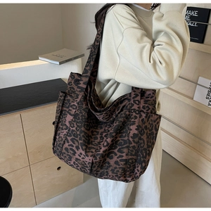 Close-up of leopard print canvas tote bag with side pocket and shoulder strap details