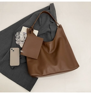 Détail macro du sac cabas marron en cuir avec pochette assortie et sa texture