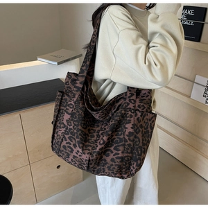 Dettaglio di una borsa tote grande in tela leopardata con tasche laterali pratiche