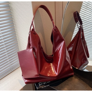Detail of large burgundy hobo shoulder bag with a matching detachable zipper pouch