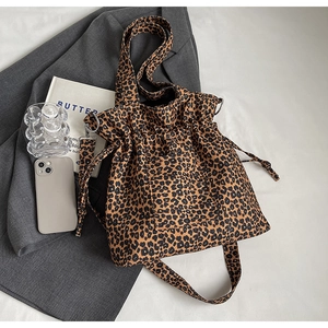 Detailed view of the leopard print canvas tote bag with drawstring closure and wide strap