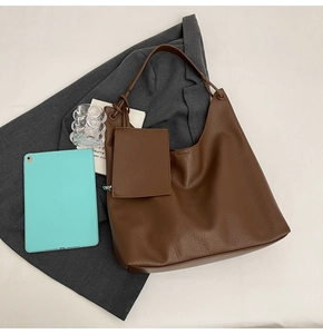Détail du sac hobo en cuir grainé marron foncé avec une petite pochette assortie