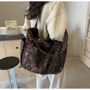Dettaglio della tracolla larga e della trama del tessuto su questa grande borsa leopardata