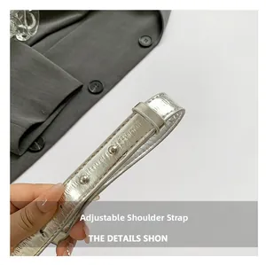 Detalle de la correa ajustable plateada con relieve brillante y hebilla de metal fina